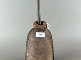 an old bell with a tag on it sitting on a table