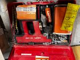 une boîte à outils rouge contenant des outils, posée par terre