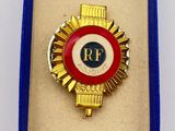 an image of a red and gold badge in a blue box