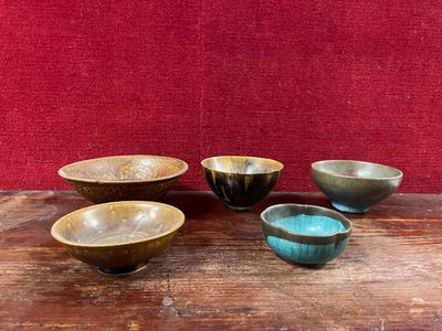 four bowls sitting on a wooden table with a red wall in the background