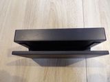 a black shelf that is on a wooden floor
