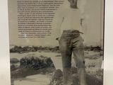 an old photo of a man standing on a beach