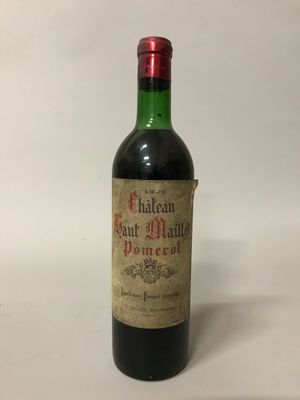 une vieille bouteille de vin posée sur une table blanche