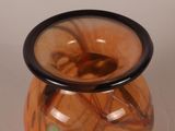 a glass vase with a black rim sitting on a table