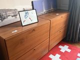 a picture of a bedroom with a red rug and a picture of a cross on the dresser