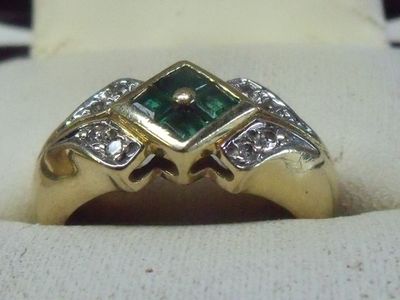 une image d'une bague en or avec une pierre verte