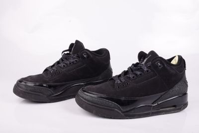 une paire de baskets noires à semelles noires sur fond blanc
