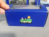 a person holding a blue box with a toy car in it