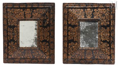 pair of ornate wooden frames with a mirror in the middle