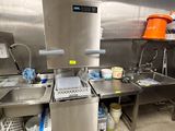 une cuisine avec de nombreux plans de travail en inox