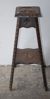 a small wooden stool with a carved seat on it