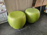two green stools sitting next to each other on the floor