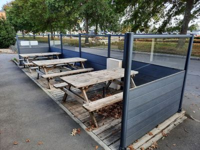 plusieurs tables de pique-nique et bancs au milieu d'un parking