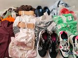 many pairs of shoes and clothes laid out on the floor