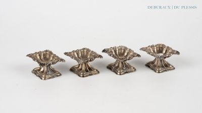 four antique silver candlesticks on a white background