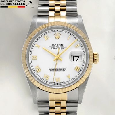 a close up of a watch with roman numerals on the dial