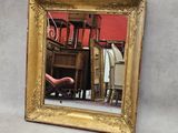 une photo d'un miroir encadré d'or accroché au mur