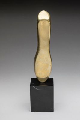 a gold sculpture of a foot on a black base