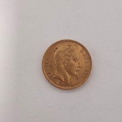 gros plan d'une pièce d'or sur une surface blanche