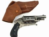un vieux revolver dans un étui en cuir, posé sur une surface blanche