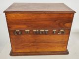 an old wooden box with many knobs on it