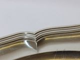 a silver plate with a curved edge on a table