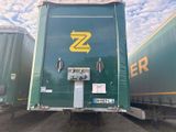 un semi-remorque vert avec un logo « Z » jaune sur le côté