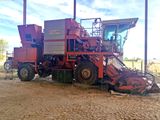 un tracteur rouge garé sur la terre battue