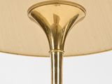 brass plated table lamp with a beige shade on a white background