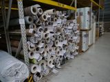 de nombreux rouleaux de papier toilette posés sur un support dans un entrepôt