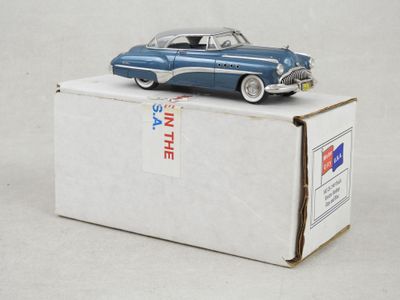 une petite voiture bleue posée sur une boîte