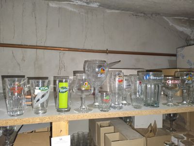 beaucoup de verres vides sur une étagère dans une pièce
