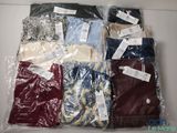 a lot of men ' s shirts in plastic bags on a table