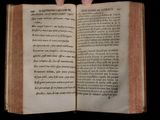 an open book with a hand holding it in front of a black background