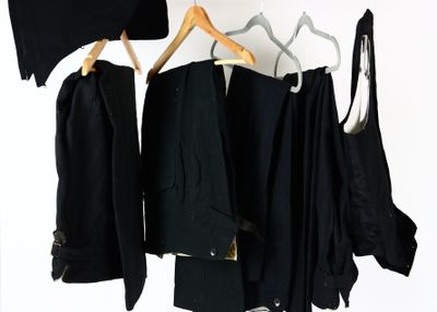 beaucoup de vêtements noirs suspendus à un portant