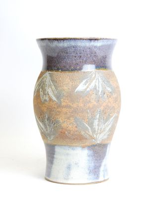 a vase that is sitting on a white surface