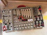 de nombreux outils dans une boîte à outils posée par terre