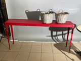 a red table with two baskets on top of it