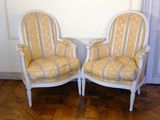 pair of yellow and white striped chairs sitting on top of a hard wood floor
