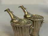 two silver vases with champagne bottles in them on a table