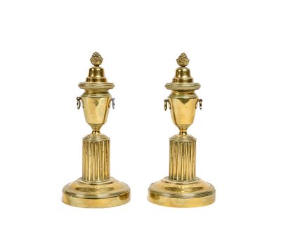 pair of antique brass candlesticks on pedestals on a white background