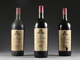 three bottles of wine are lined up on a table