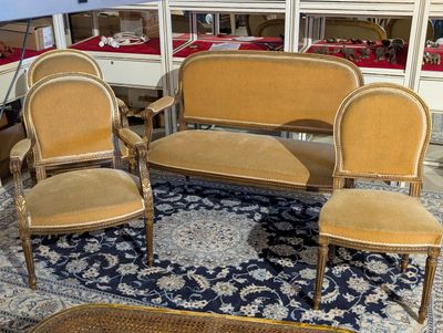 four chairs and a couch in a room with a rug on the floor