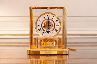 a gold clock sitting on top of a shiny table