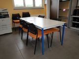 a white table with orange chairs and a black printer