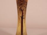a glass vase with a tree on it on a table
