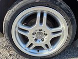 the tire of a white car with a flat tire on a gravel road