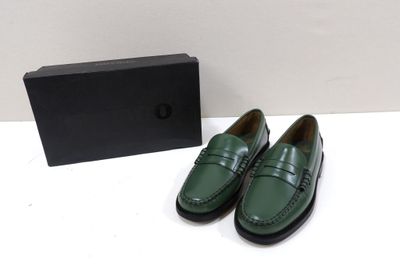une paire de chaussures vertes posée à côté d'une boîte noire
