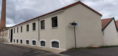 a white building with a brick chimney on the side of it