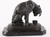 une statue en bronze représentant un chien et un chat, posée sur un socle en marbre